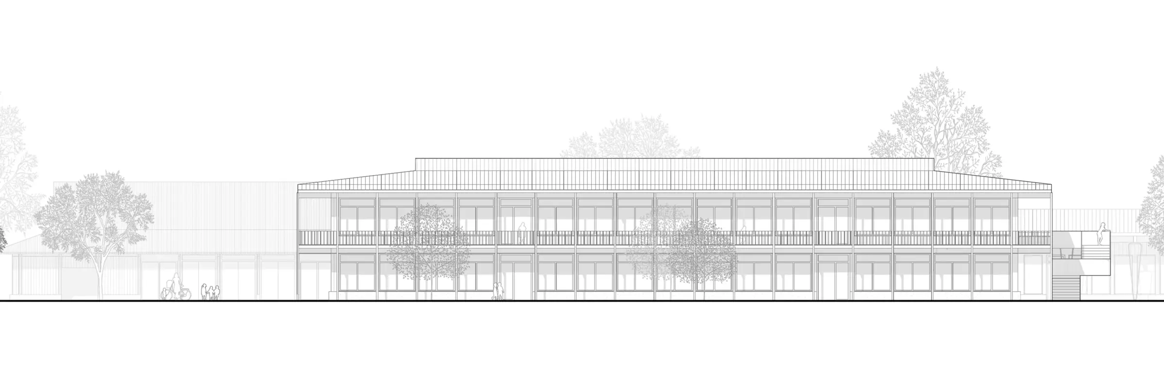 Ansicht von Osten eines langgestreckten zweigeschossigen Schulgebäudes mit durchlaufender Fensterfront und Bäumen davor.