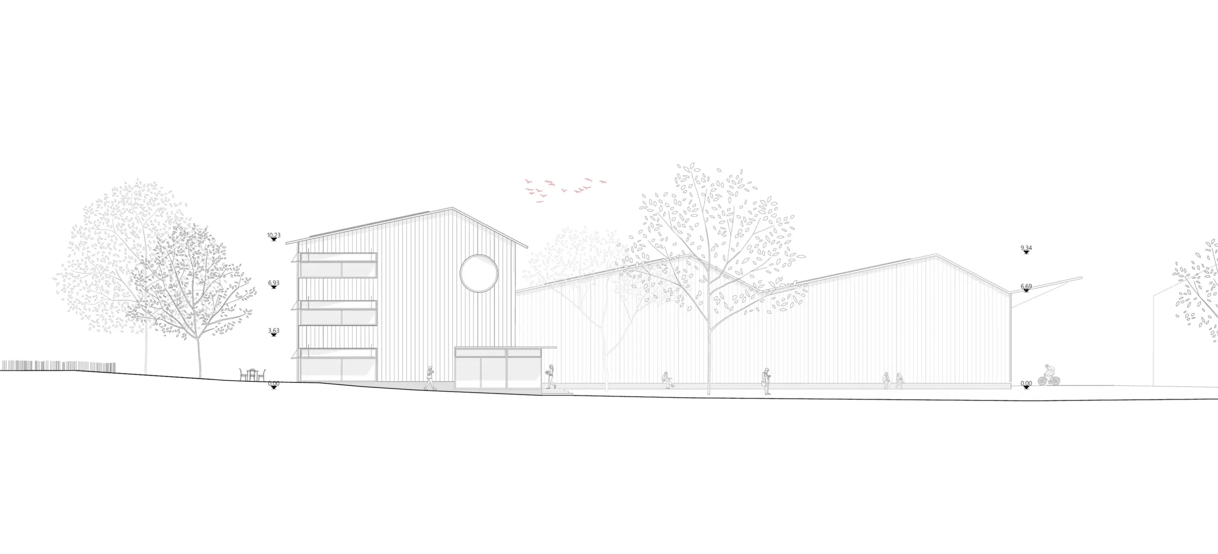 Ansicht von Osten zeigt ein giebelständiges Gebäude mit Rundfenster neben flacheren Shedbau-Volumen, umgeben von Bäumen.